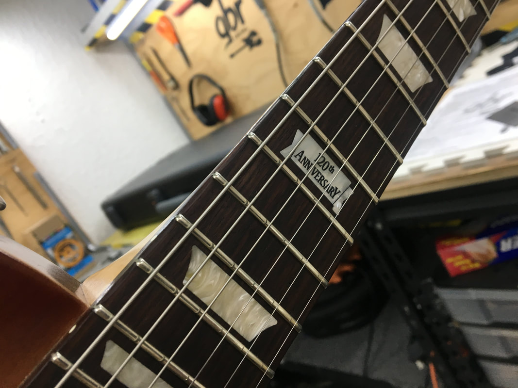 Primer plano mástil de guitarra con diapasón y cuerdas