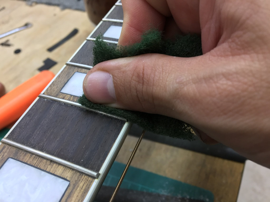 Foto de reparación de incrustación en diapasón de guitarra acústica